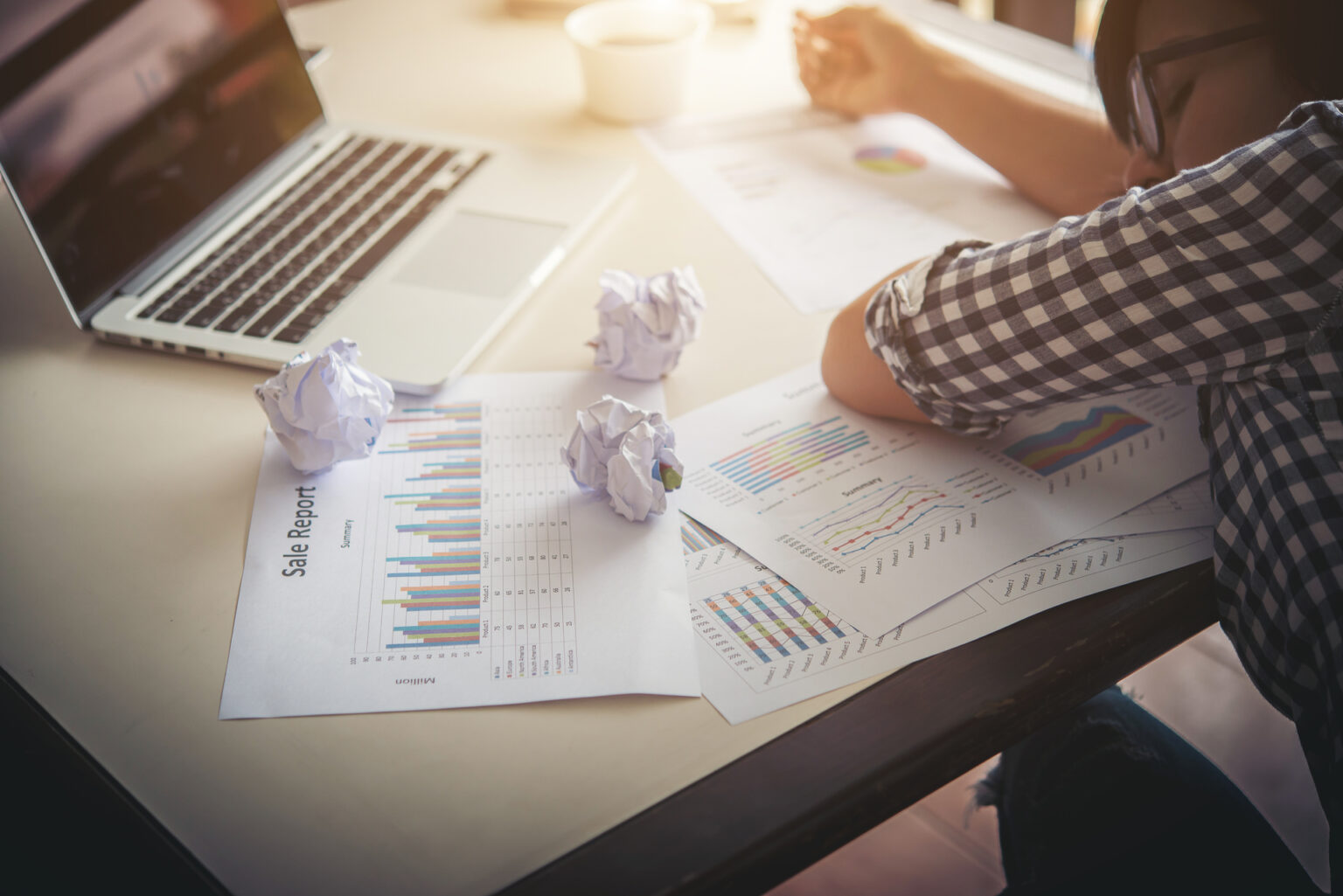 Entrepreneure fatiguée endormie sur son ordinateur portable, entourée de papiers et documents, illustrant le stress, la surcharge de travail et le risque de burn-out au bureau.