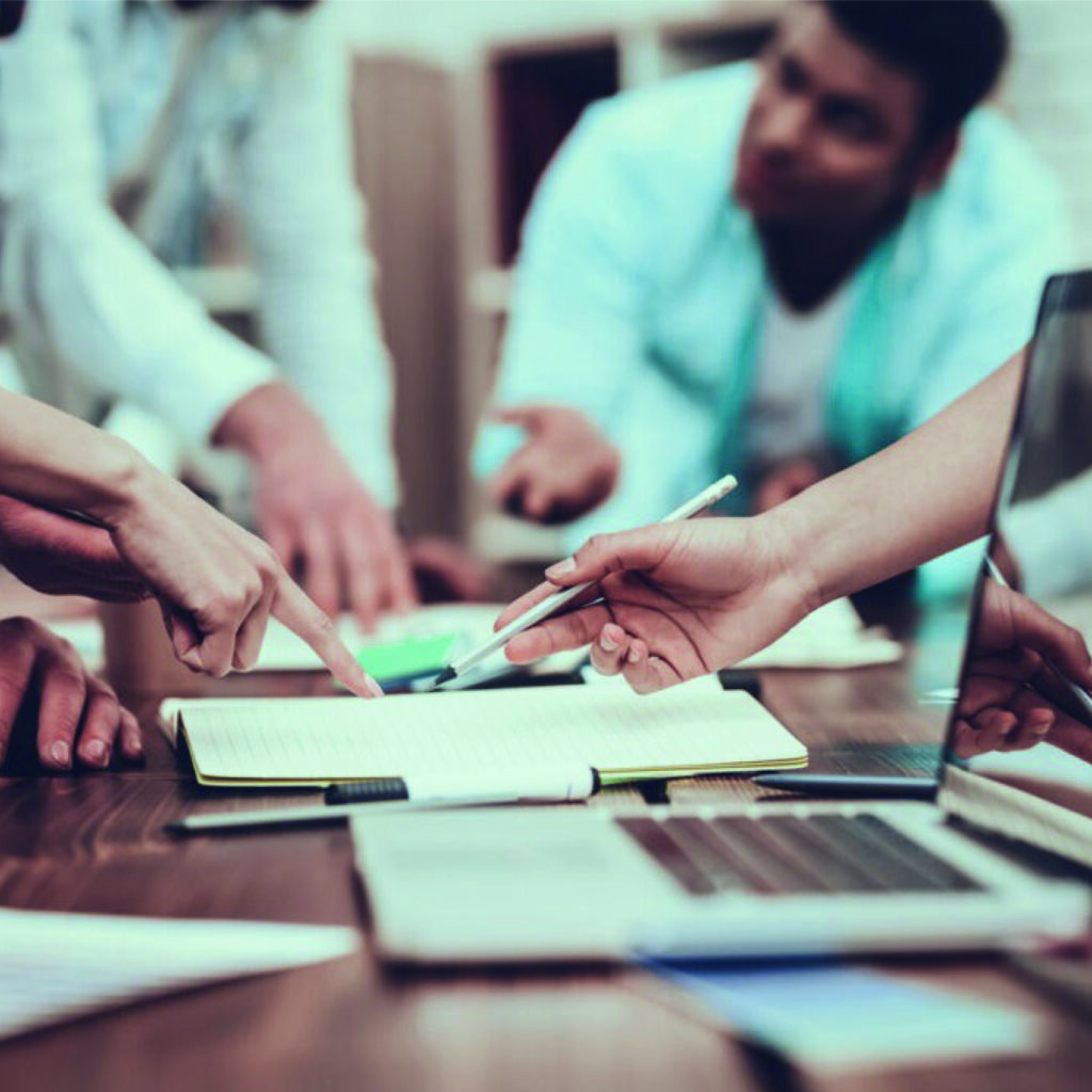 Groupe de travail en réunion autour d’un bureau avec un ordinateur portable, en pleine élaboration de stratégie d’entreprise.