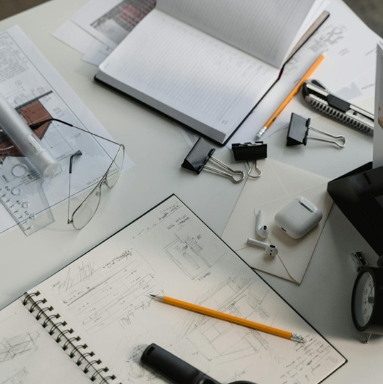Bureau d’un porteur de projet CHR avec plans architecturaux, croquis et documents de préparation.