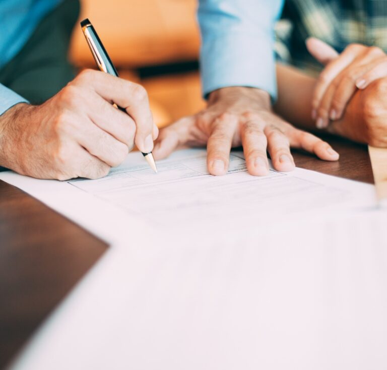 Repreneur de projet CHR en train de signer des documents avec un accompagnement professionnel.